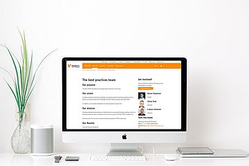Computer screen on desk in white/minimalist surroundings showing Best Practices Team's web page.