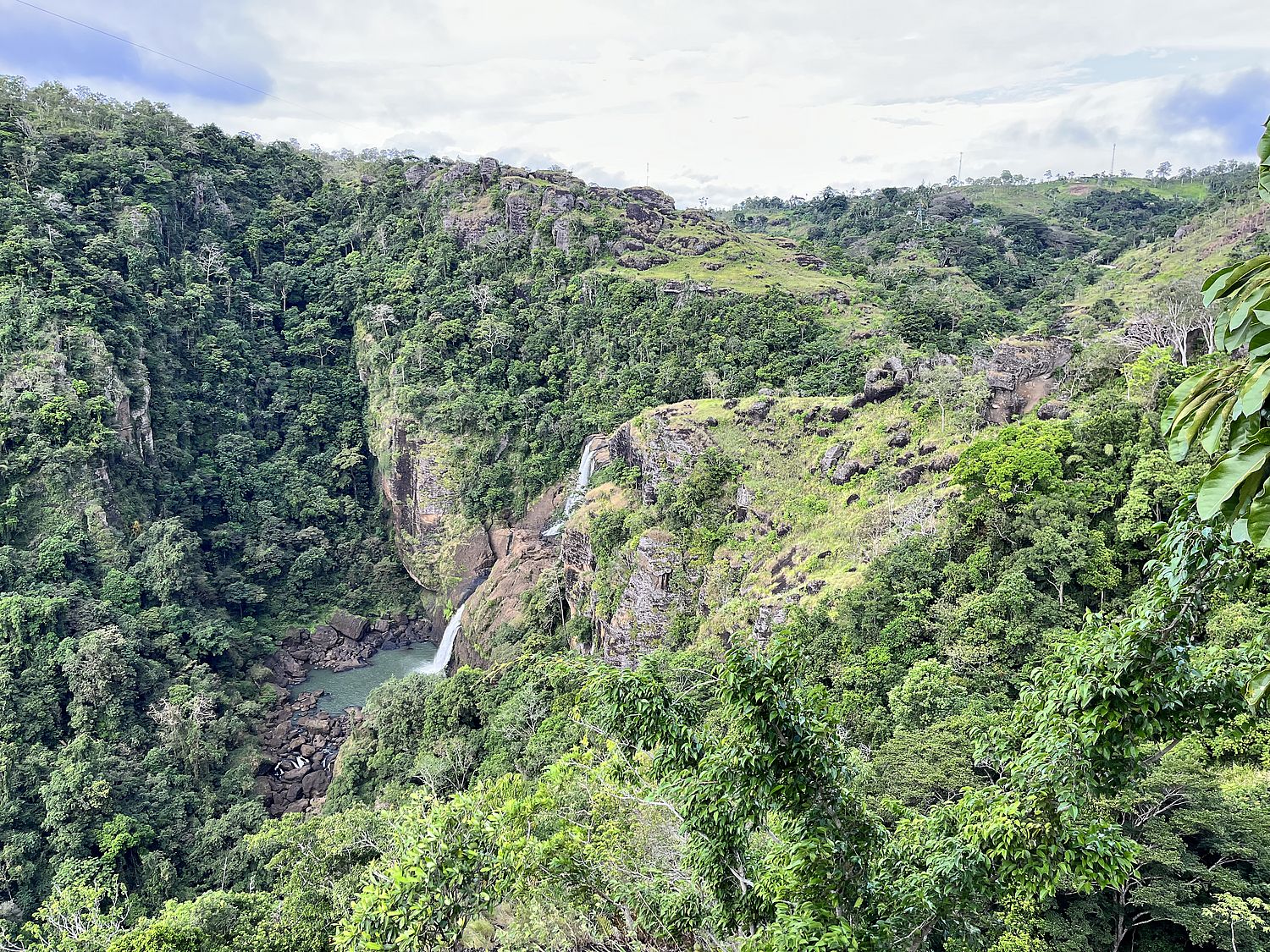 Gorge with waterfall and green forest.